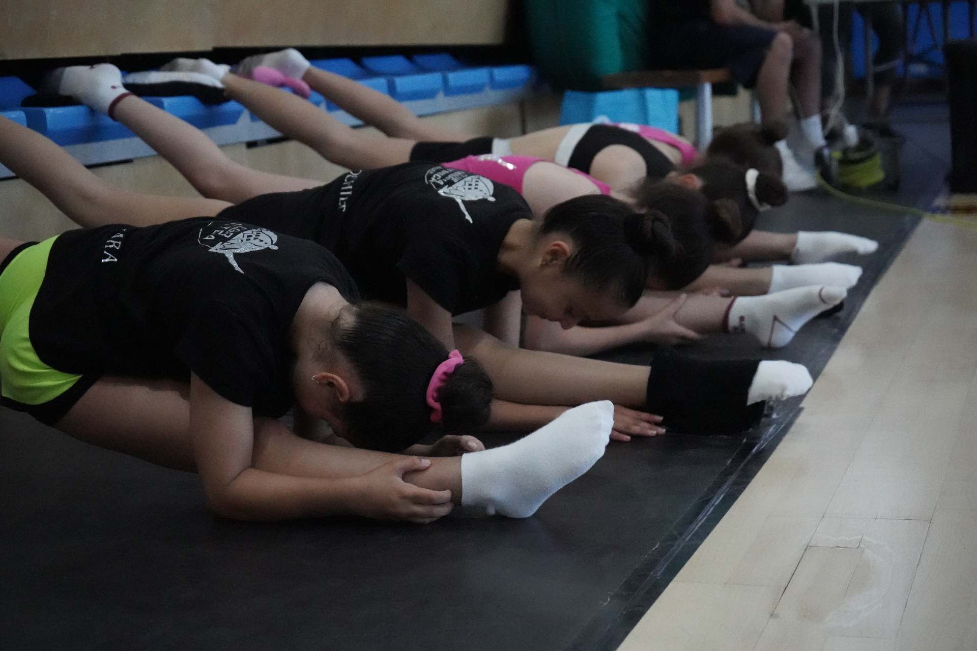 Gimnastas del club realizando estiramientos en fila